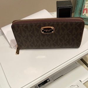 Micheal Kors Monogramed brown wallet size about 9 inches long 5 inches wide